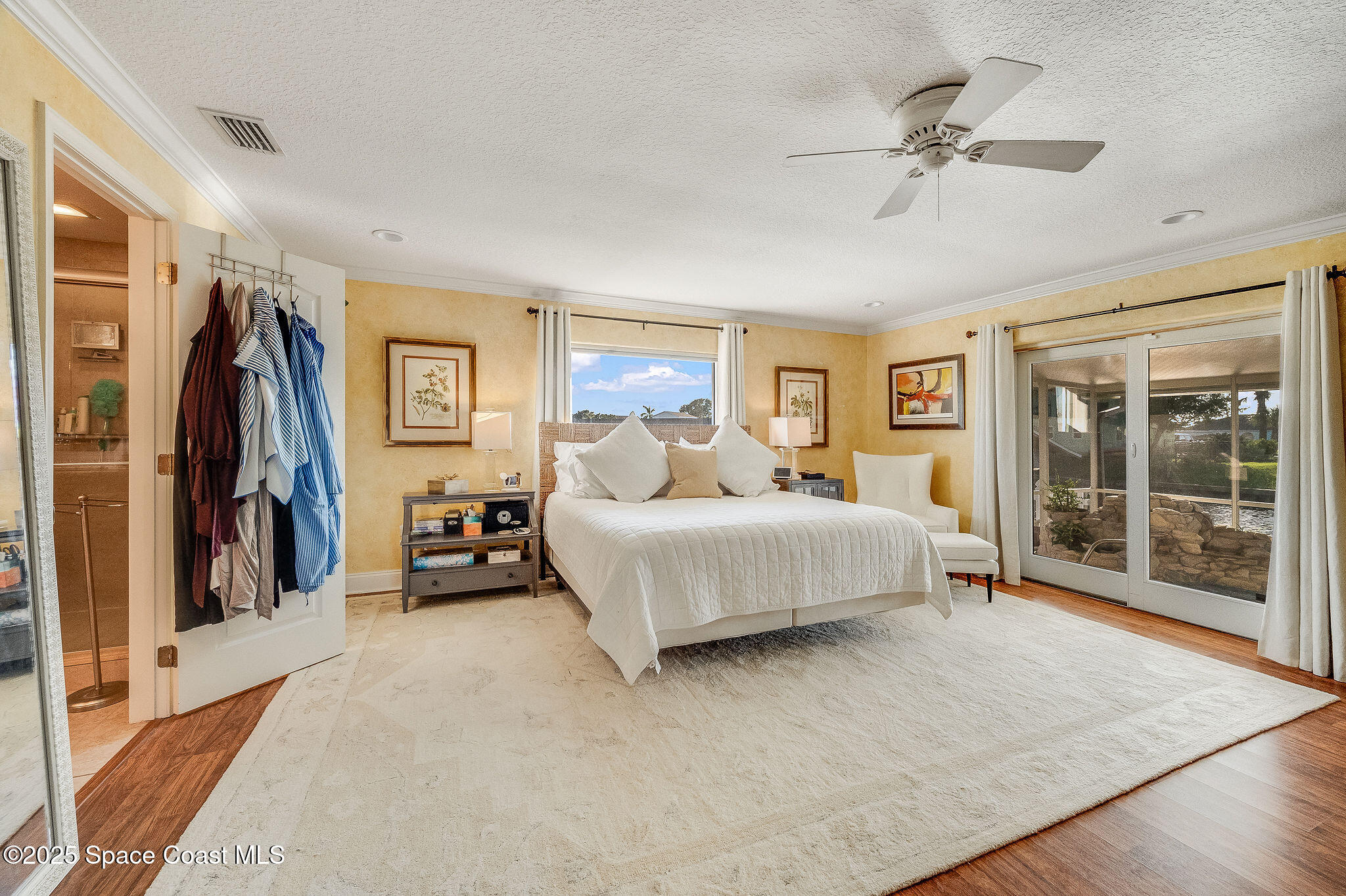 1480 West Riviera Drive Merritt Island, FL 32952 - Photo 32 of 93 a spacious bedroom with a large bed and a chandelier