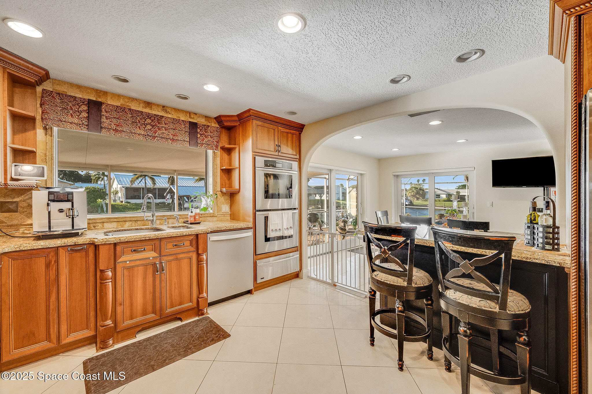 1480 West Riviera Drive Merritt Island, FL 32952 - Photo 10 of 93 a kitchen with stainless steel appliances kitchen island granite countertop a table and chairs