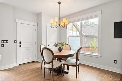a dining room with furniture a chandelier and wooden floor