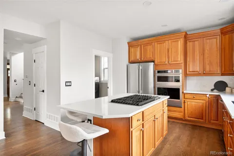 a kitchen with stainless steel appliances kitchen island granite countertop a sink stove and refrigerator