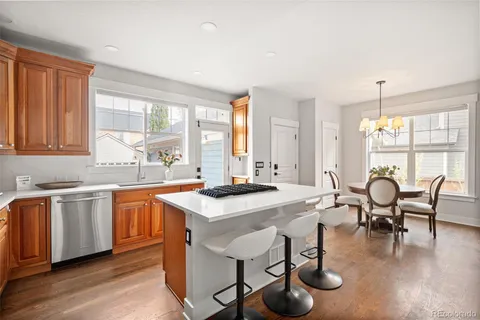 a open dining room with stainless steel appliances granite countertop a kitchen island a stove a table and chairs