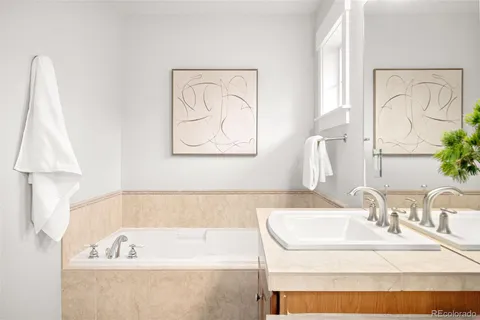 a bathroom with a tub sink and mirror