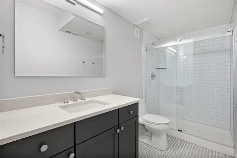 a bathroom with a sink toilet a mirror and shower
