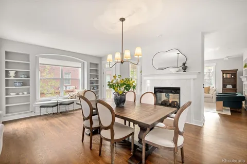 a dining room with furniture a chandelier and wooden floor