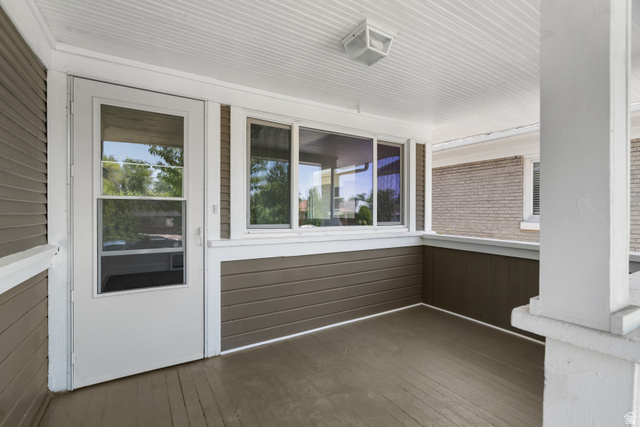 2862 Fowler Avenue Ogden, UT 84403 - Photo 5 of 23 Enclosed porch featuring a white screen door, expansive windows, a tongue-and-groove ceiling, and wood-finish flooring