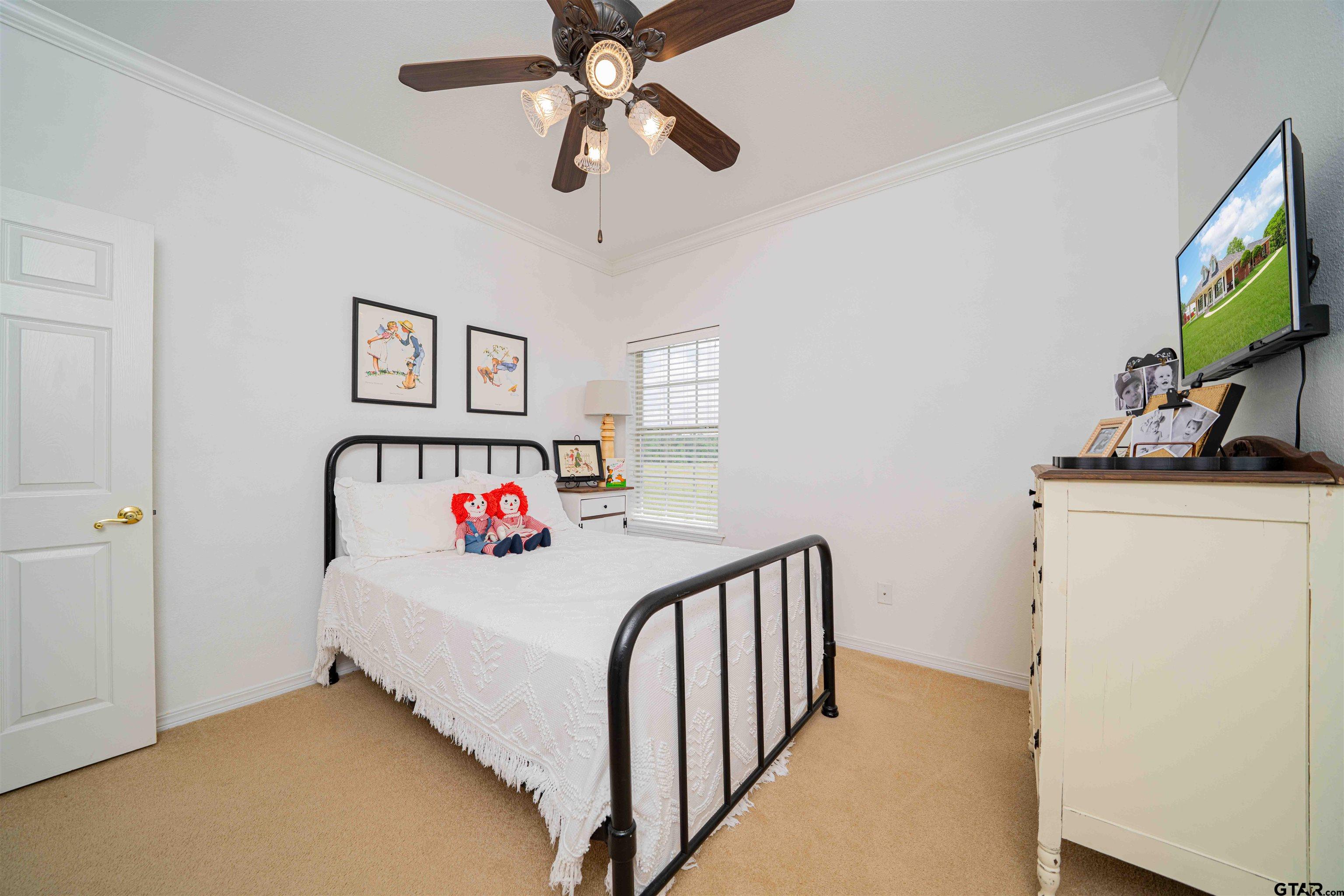 1855 Phillips Springs Road Gladewater, TX 75647 - Photo 10 of 36 a bedroom with a bed and a flat tv screen on dresser