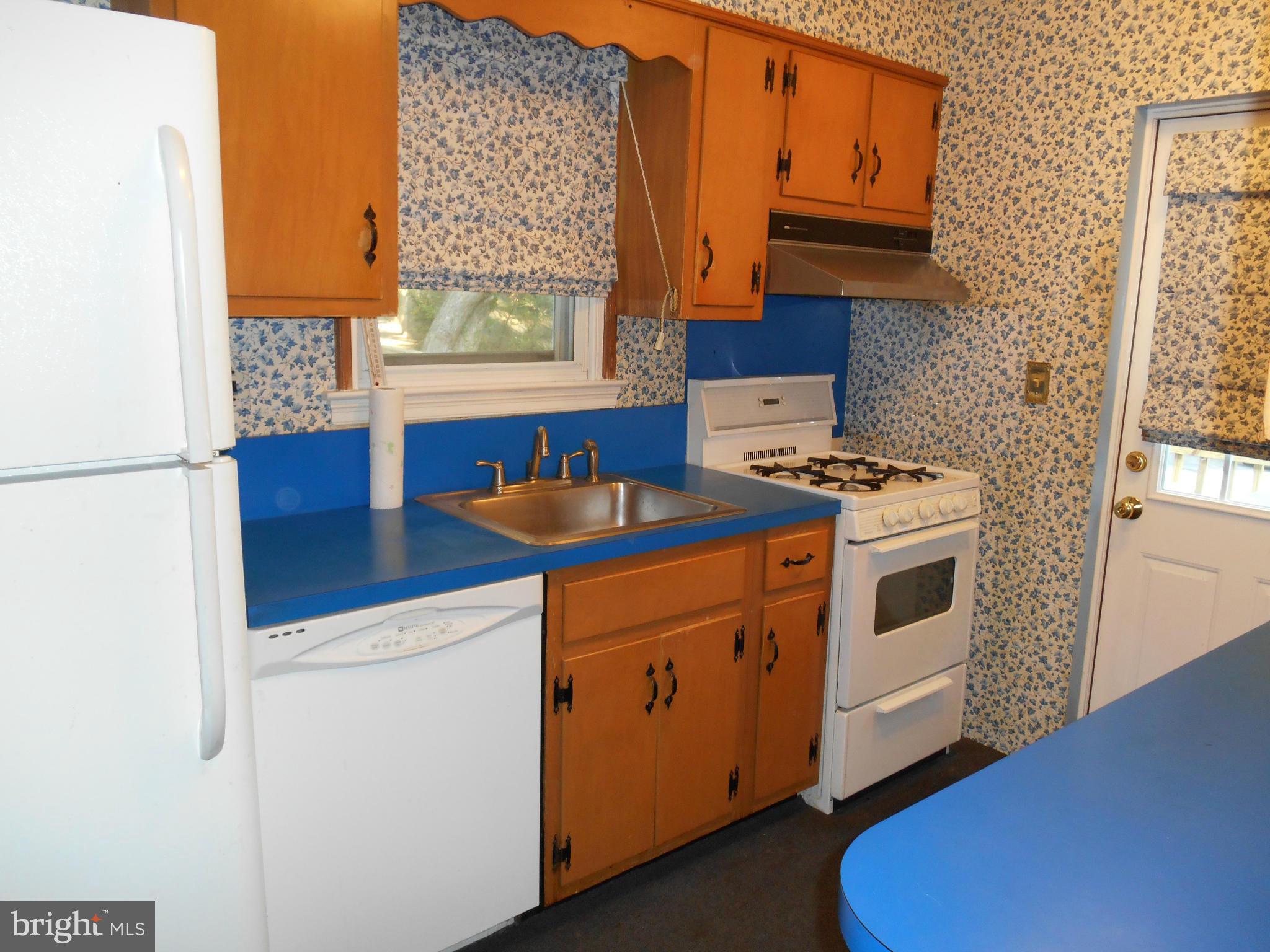 6403 Crestwood Road Baltimore, MD 21239 - Photo 11 of 15 a kitchen with a stove cabinets and a refrigerator