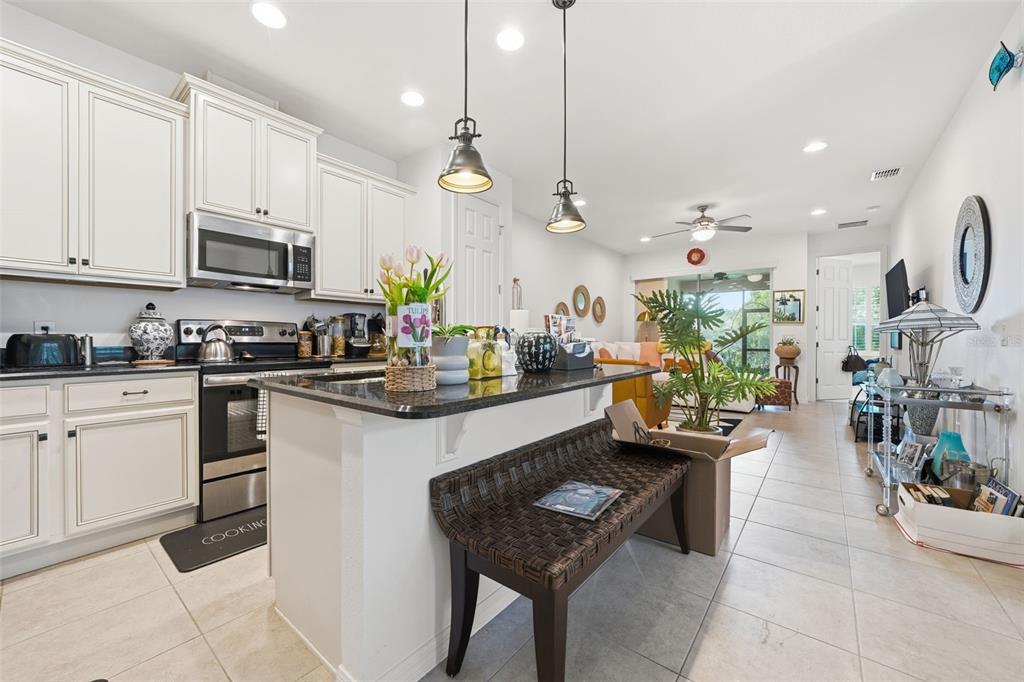 3461 Fallbrook Drive Kissimmee, FL 34759 - Photo 12 of 43 a kitchen with stainless steel appliances kitchen island granite countertop a stove a sink and a refrigerator