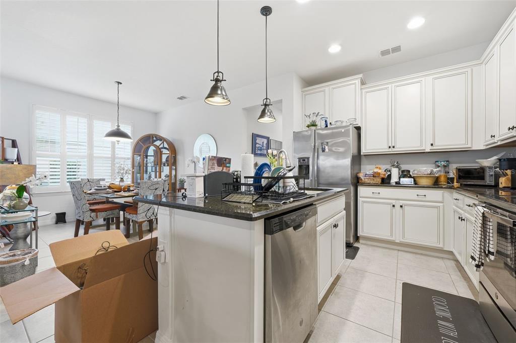 3461 Fallbrook Drive Kissimmee, FL 34759 - Photo 14 of 43 a kitchen with stainless steel appliances granite countertop a stove a sink dishwasher and a refrigerator with wooden floor