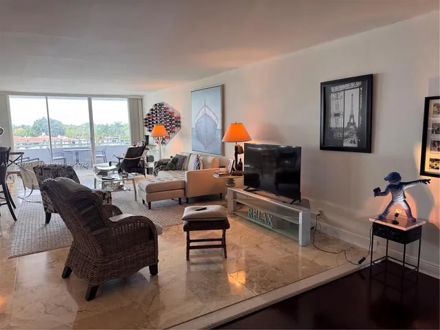 a living room with furniture and a flat screen tv with wooden floor