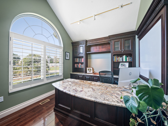13357 Trail Rider Circle Draper, UT 84020 - Photo 23 of 70 Arched window with plantation shutters, featuring a built-in desk with a stone countertop, custom cabinetry, and hardwood flooring