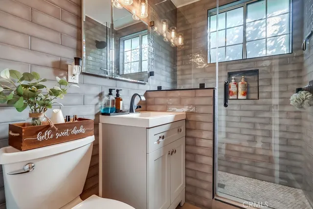 a bathroom with a sink toilet vanity and window