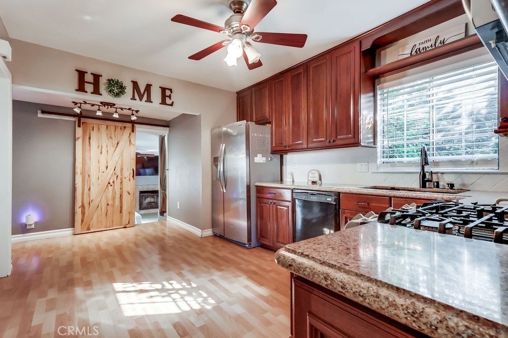 5202 Fidler Avenue Lakewood, CA 90712 - Photo 9 of 30 a kitchen with stainless steel appliances granite countertop a sink stove and refrigerator