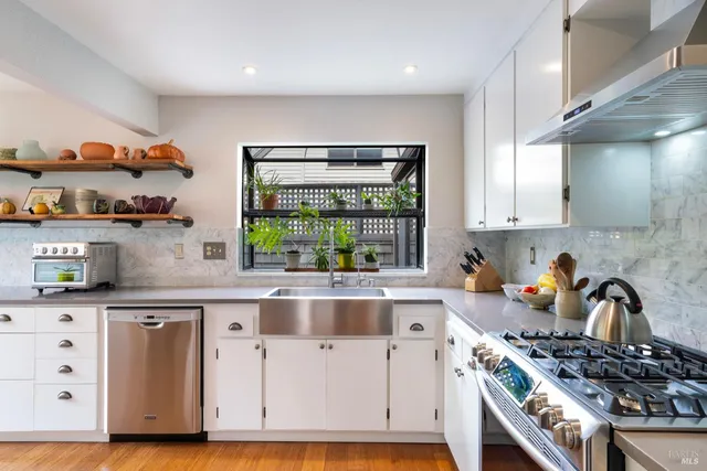 a kitchen with stainless steel appliances granite countertop a stove a sink and a refrigerator