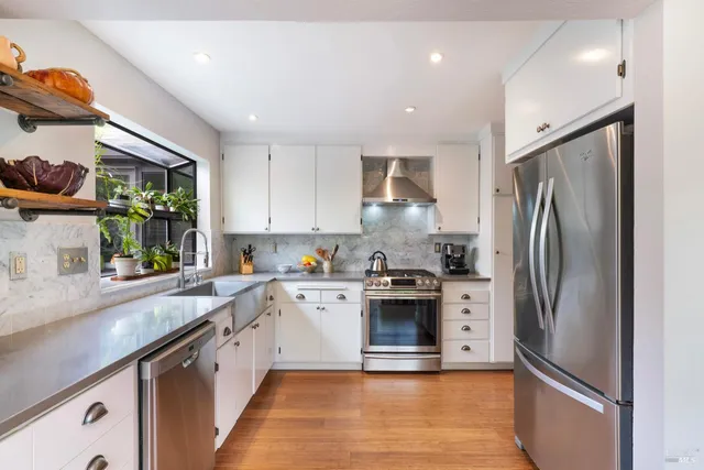 a kitchen with stainless steel appliances granite countertop a refrigerator sink and stove