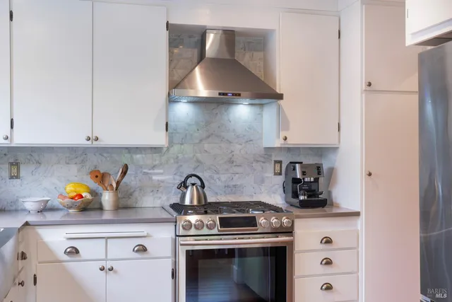 a kitchen with a stove and white cabinets