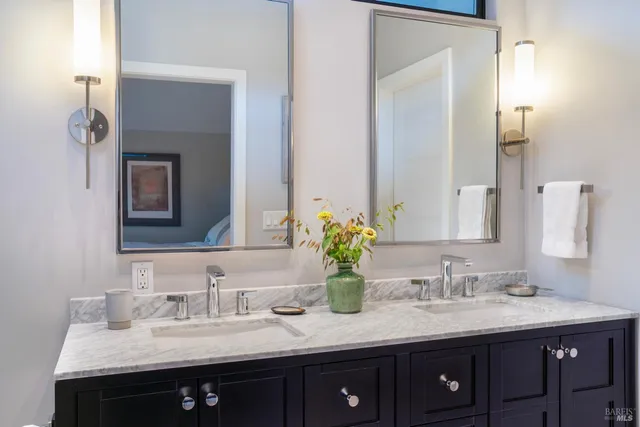 a bathroom with double sink and a mirror