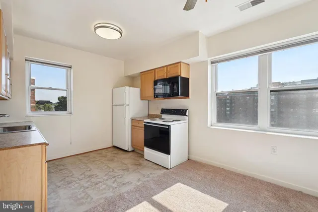 a view of a kitchen with a stove cabinets and a living room