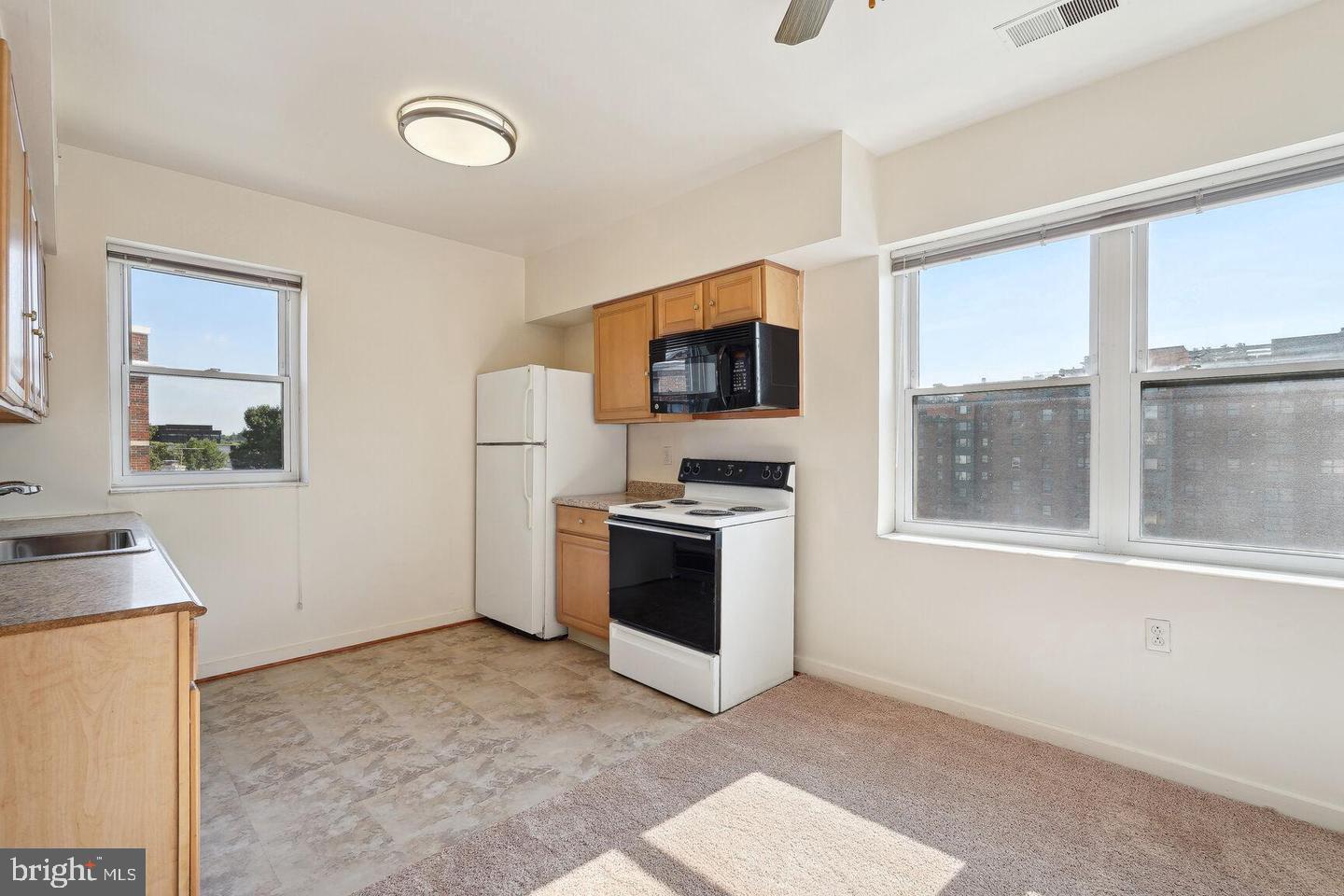 55 M Street Northwest, Unit 406 Washington, DC 20001 - Photo 11 of 23 a view of a kitchen with a stove cabinets and a living room