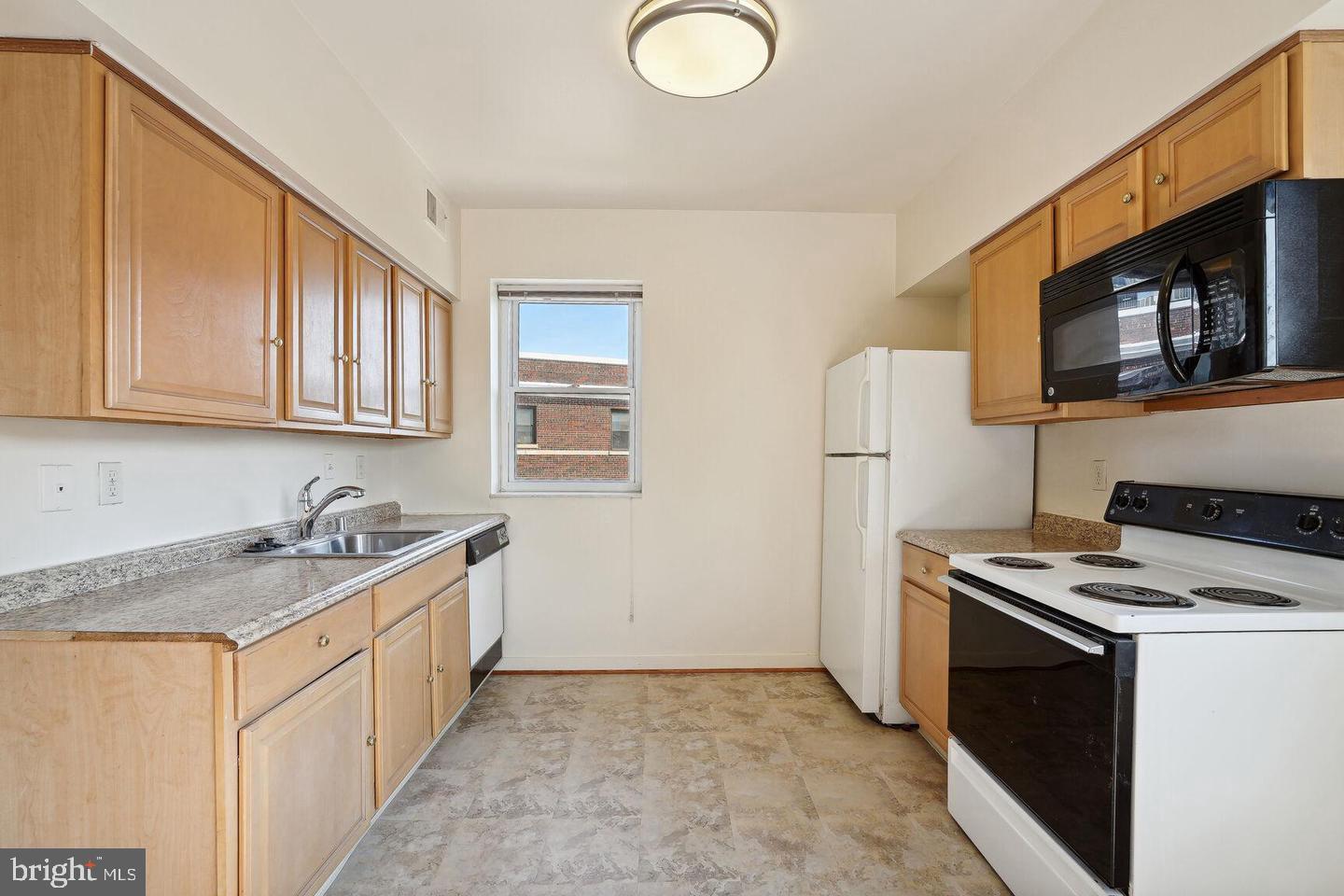 55 M Street Northwest, Unit 406 Washington, DC 20001 - Photo 10 of 23 a kitchen with stainless steel appliances granite countertop a stove a sink and a microwave