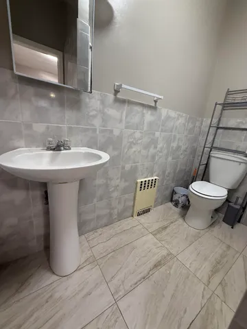 a bathroom with a sink toilet and a mirror