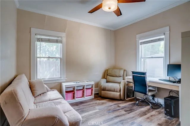 a work room with furniture a bookshelf and a window