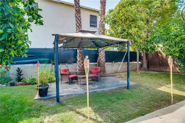 a view of house with backyard and furniture