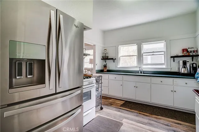 a kitchen with granite countertop a sink stove and cabinets