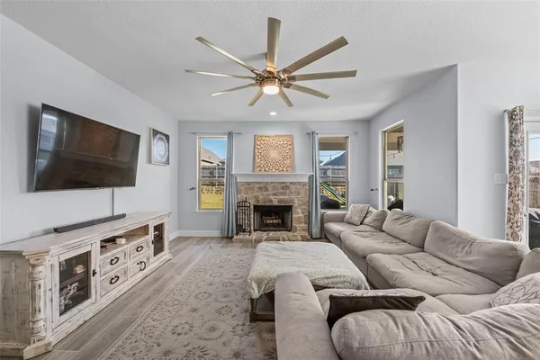a living room with furniture a fireplace and a large window