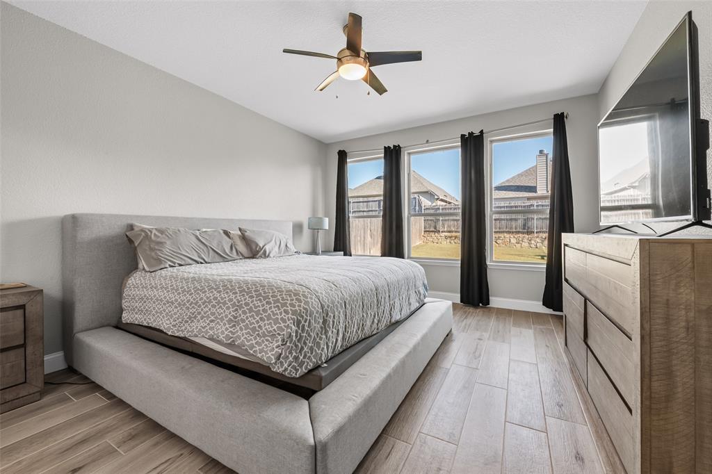 3709 Juniperio Street Denton, TX 76208 - Photo 16 of 31 a spacious bedroom with a large bed and a chandelier