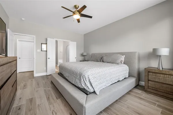 a spacious bedroom with a large bed and a chandelier
