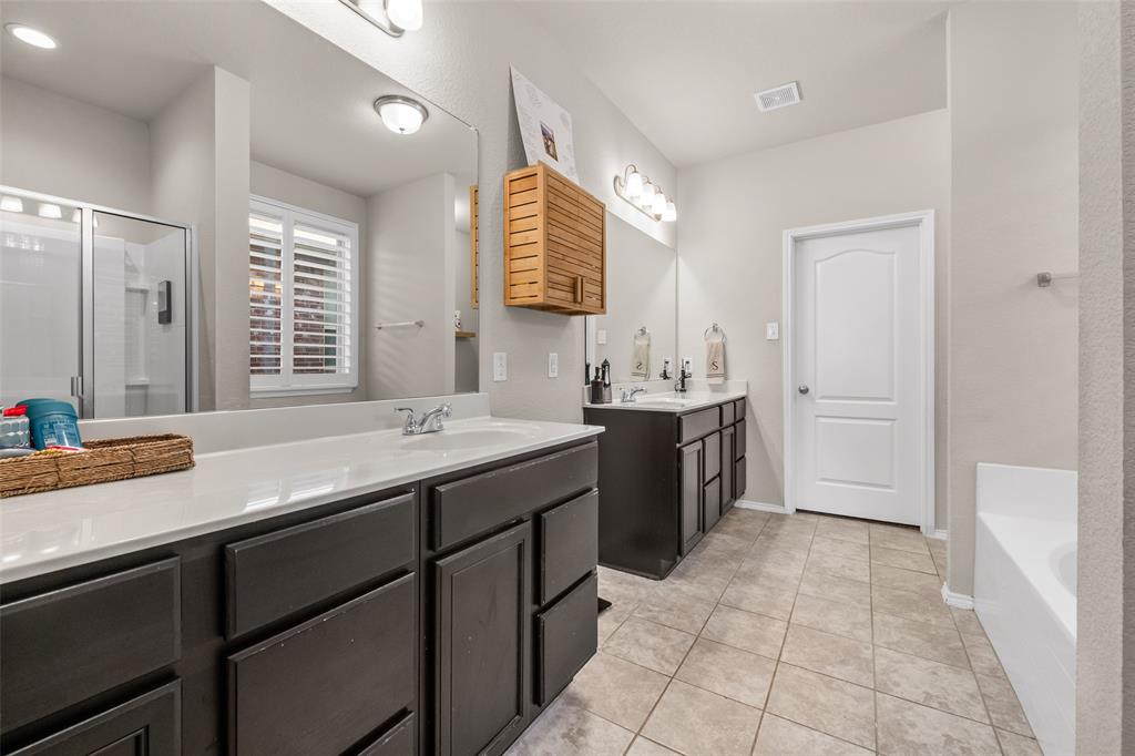 3709 Juniperio Street Denton, TX 76208 - Photo 18 of 31 a spacious bathroom with a granite countertop sink a mirror and a