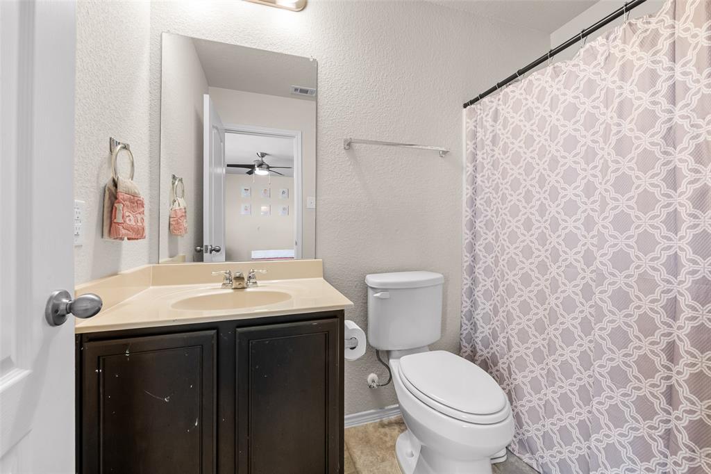 3709 Juniperio Street Denton, TX 76208 - Photo 24 of 31 a bathroom with a toilet a sink and mirror