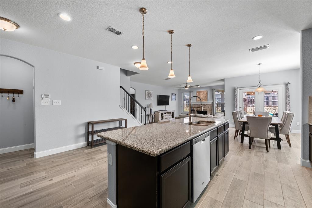 3709 Juniperio Street Denton, TX 76208 - Photo 31 of 31 a kitchen with a kitchen island a sink dining table and chairs