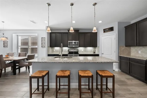 a kitchen with a kitchen island a sink dining table and chairs