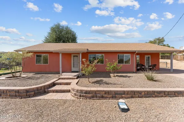 a view of a house with backyard and sitting area