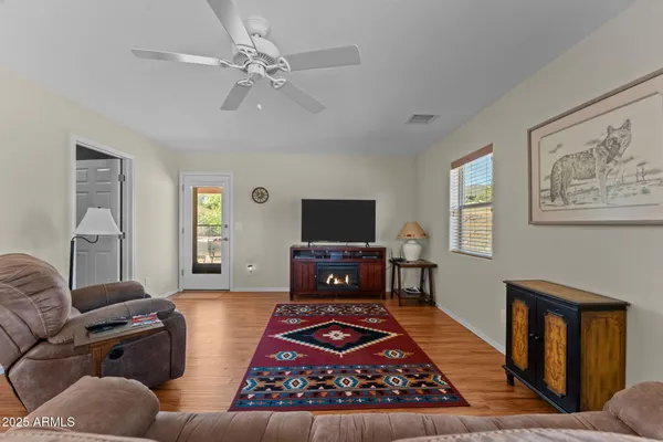a living room with furniture a flat screen tv and a window