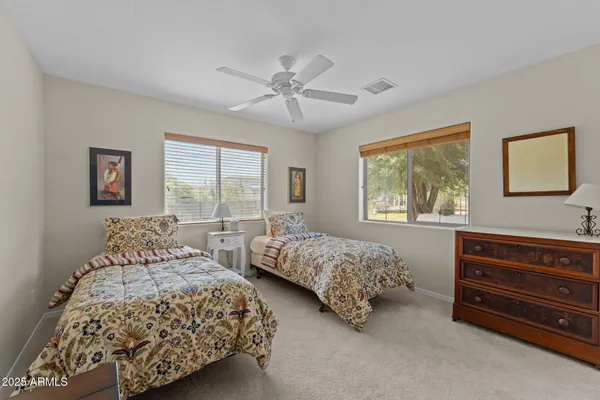 a bedroom with two beds and a dresser