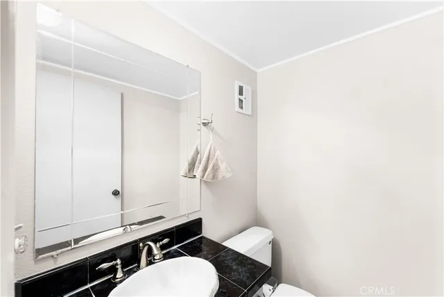 a bathroom with a sink a toilet a mirror and shower