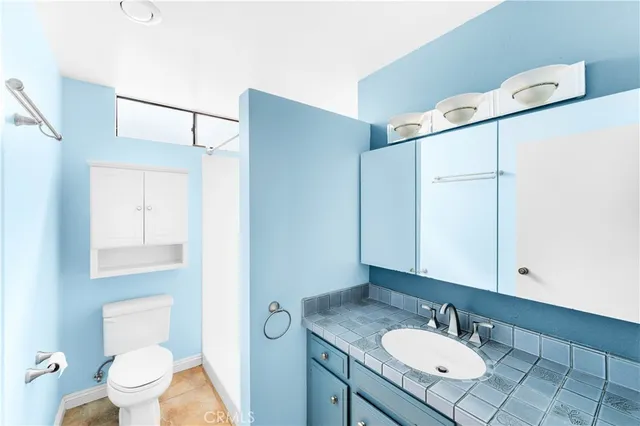 a bathroom with a granite countertop sink toilet and shower