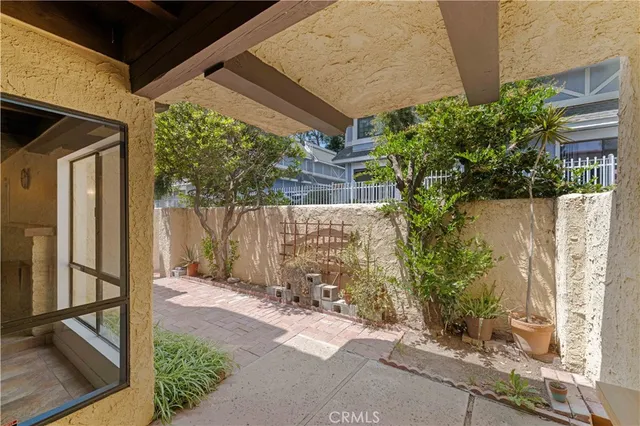 a backyard of a house with plants and outdoor seating