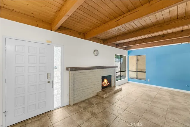 a view of an empty room with a fireplace and a window