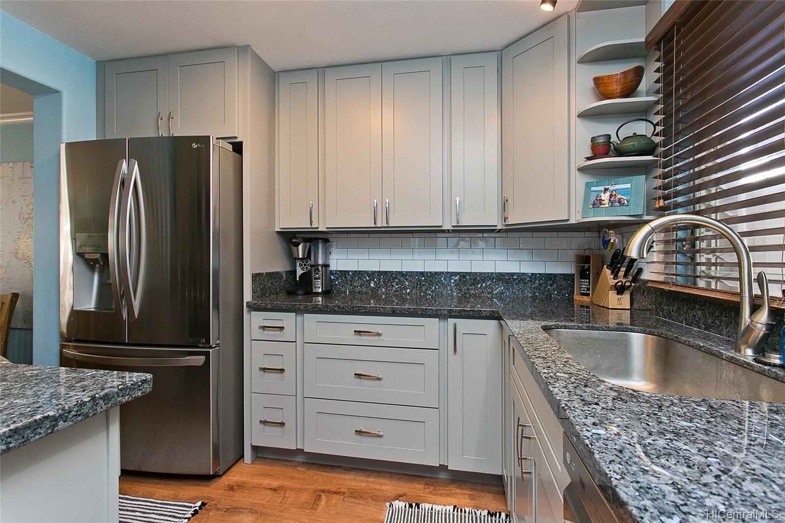 a kitchen with granite countertop a refrigerator a stove and a sink