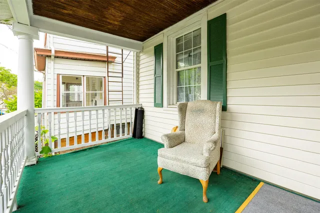 a view of a chair in the backyard with wooden fence