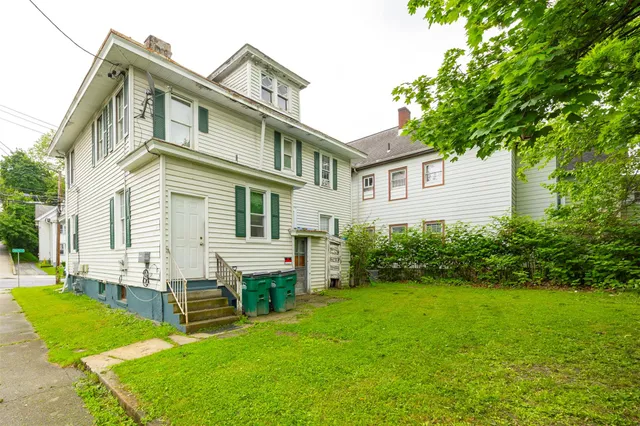 a front view of a house with a yard and trees