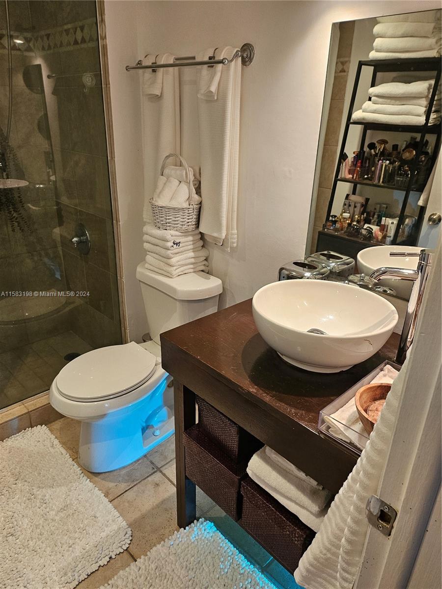 1605 Bay Road, Unit 406 Miami Beach, FL 33139 - Photo 21 of 31 a bathroom with a sink a toilet a mirror and shower