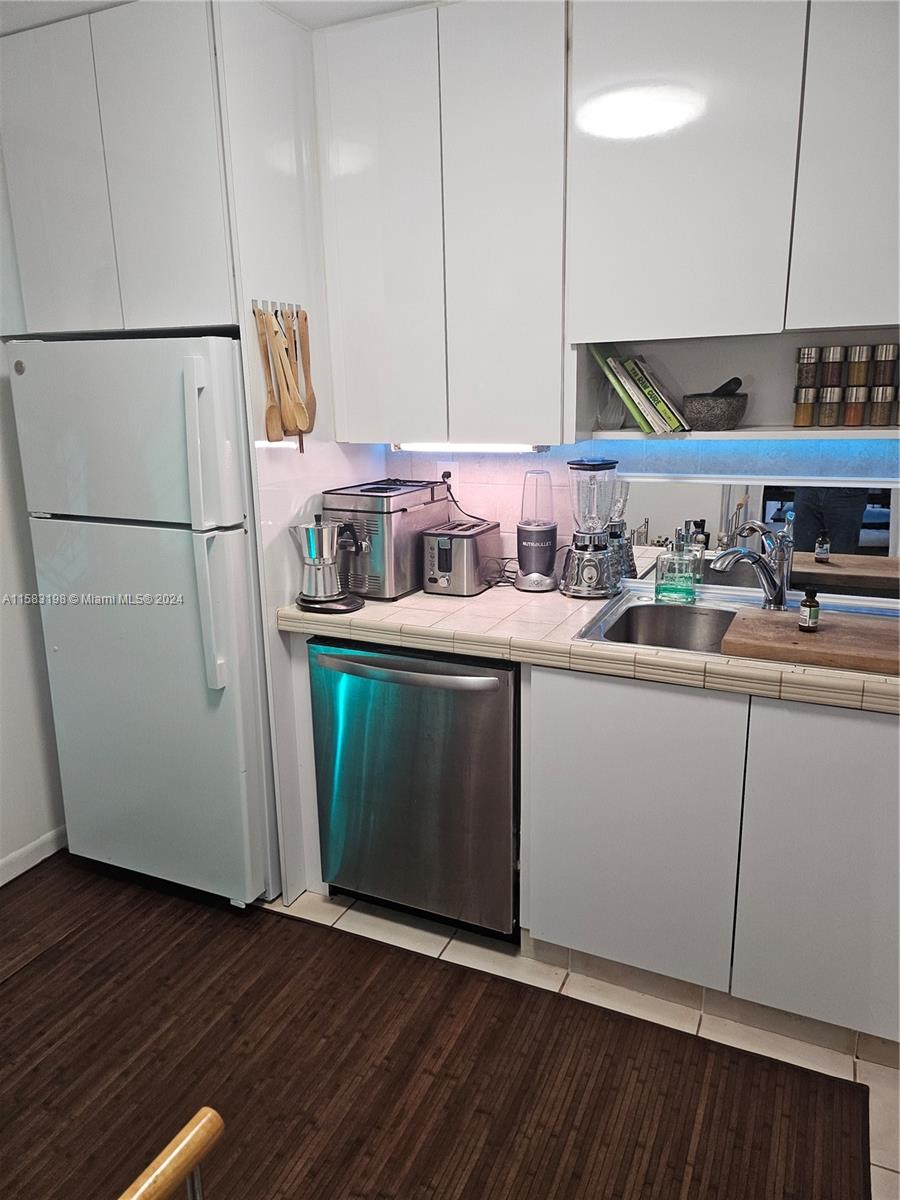 1605 Bay Road, Unit 406 Miami Beach, FL 33139 - Photo 24 of 31 a kitchen with sink a refrigerator and wooden floor