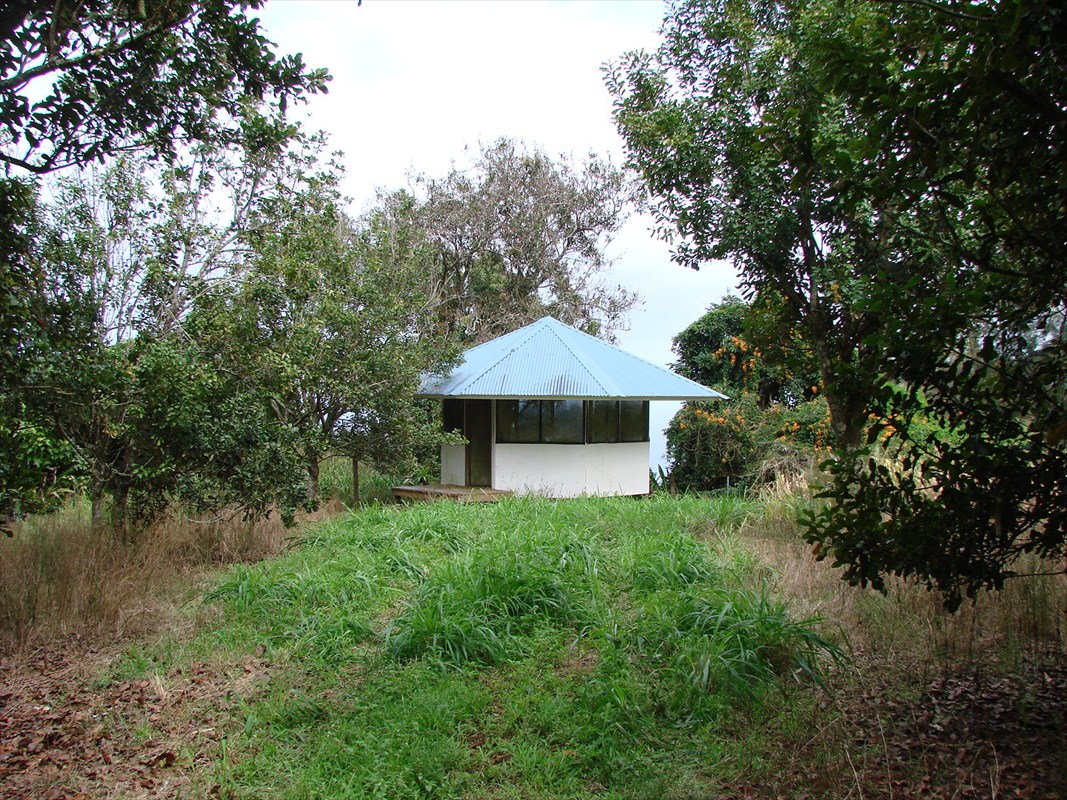 47-4630 Cane Haul Road Honokaa, HI 96727 - Photo 7 of 9 a backyard of a house with table and chairs under an umbrella