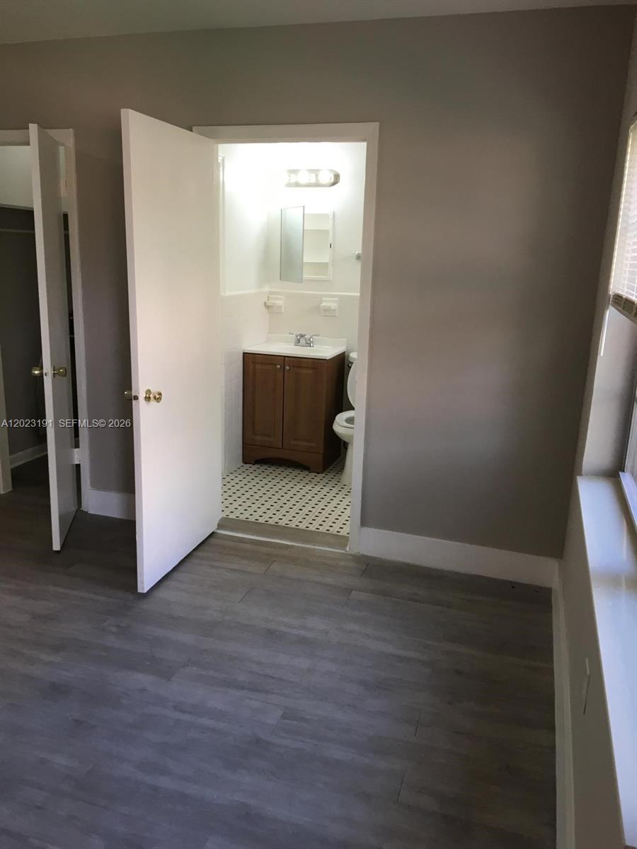 520 Southwest 4th Street, Unit 5 Miami, FL 33130 - Photo 3 of 11 an empty room with wooden floor and a window