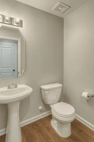 a bathroom with a toilet a sink and mirror